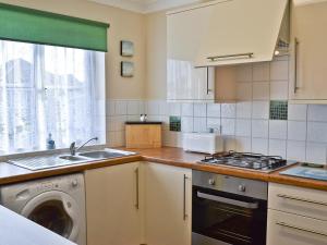 a kitchen with a sink and a washing machine at Sea Breeze Bungalow in Sutton on Sea