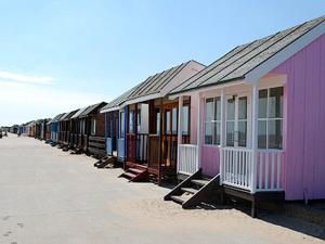 a row of colorful homes on a beach at Sea Breeze Bungalow in Sutton on Sea