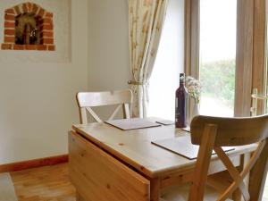 a wooden desk with a chair next to a window at Hay Loft -23894 in Aylmerton