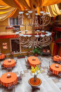 クエンカにあるHotel Campanarioの大きなダイニングルーム(オレンジのテーブル、シャンデリア付)