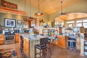 a kitchen with a large center island with bar stools at Unique Del Norte Getaway on 50 Private Acres! in Del Norte