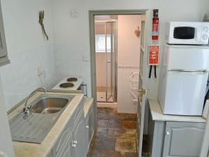 a small kitchen with a sink and a refrigerator at The Pocker Watch in Chideock