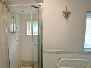 a shower with a glass door in a bathroom at The Pocker Watch in Chideock