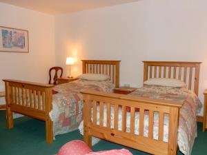 Habitación de hotel con 2 camas y 2 lámparas en Nellys Cottage en Lanehead