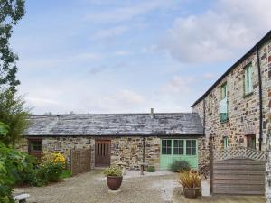 an old stone building with a green door at The Coach House - 24439 in Bodmin