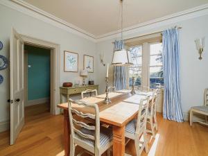 a dining room with a wooden table and chairs at The Glen Farmhouse in Crocketford