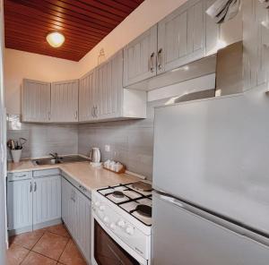 cocina con armarios blancos y nevera blanca en Apartments Zoričić, en Novi Vinodolski
