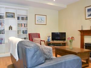 a living room with a couch and a table at Aira Cottage in Watermillock