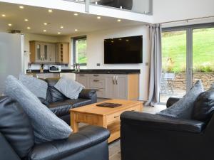 a living room with two couches and a table at Heartwell Cottage in Wolsingham