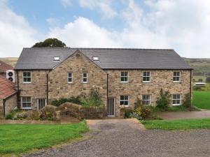 a large stone house with a yard at Heartwell Cottage in Wolsingham