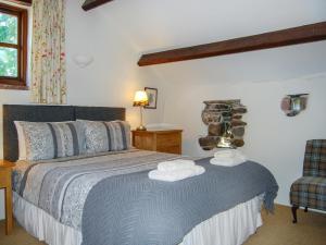 a bedroom with a bed with two towels on it at The Garth in Mungrisdale