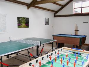 a room with two ping pong tables and a piano at The Garth in Mungrisdale