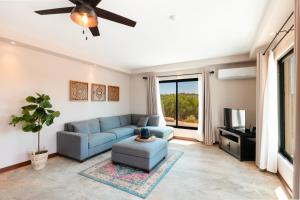 恩塞納達港的住宿－Sarab Hotel，客厅配有蓝色的沙发和电视