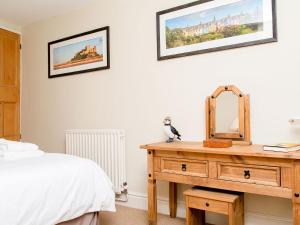 1 dormitorio con 1 cama y vestidor con espejo en Harrys Den, en Alnwick
