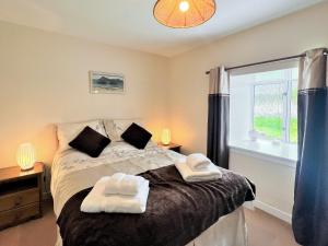 Un pat sau paturi într-o cameră la Burnside Cottage