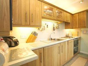 a kitchen with wooden cabinets and a sink at Badgers Rake 7 in Ambleside
