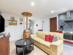 a living room with a couch and a table at Cozy holiday home in Flemish Brabant with swimming pool in Zoutleeuw