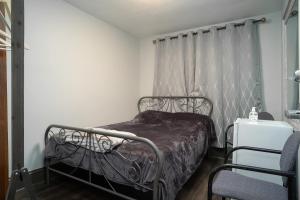 a bedroom with a metal bed with a curtain at Private room #1 downtown ottawa in Ottawa