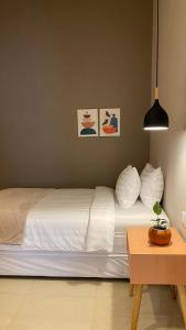 ein Schlafzimmer mit einem weißen Bett und einem Tisch in der Unterkunft The Pines Smart Homes in Batu