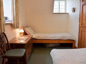 LlangadogにあるMarlaisのベッド2台、デスク、椅子が備わる客室です。