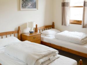 A bed or beds in a room at Lochinchard Cottages