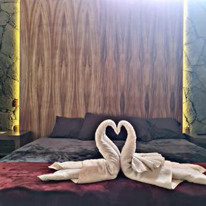 dois cisnes a fazer um coração numa cama em No. 2 Encantador Loft Jacuzzi Mazamitla em Mazamitla