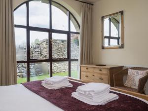 a bedroom with a bed with a large window at The Byre - Ifw in Airton