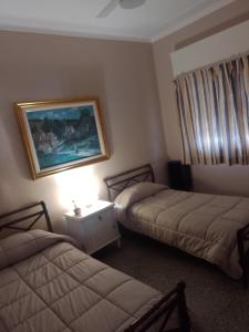 Habitación de hotel con 2 camas y una foto en la pared en Altos de Quintana Alojamiento compartido en Tandil