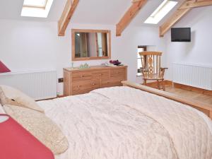 a bedroom with a large bed and a chair at The Farmhouse in Llanarth