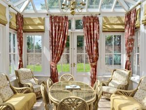 a conservatory with a table and chairs and windows at The Limes in Swanwick