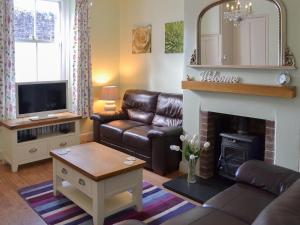 a living room with a couch and a fireplace at Lavender Cottage in Buckfastleigh