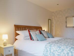 a bedroom with a large white bed with pillows at Well Cottage in Ceres