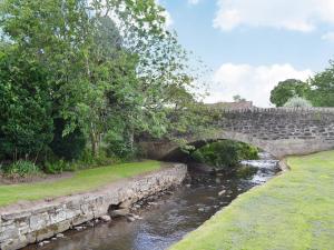 a stone bridge over a river in a park at Well Cottage in Ceres