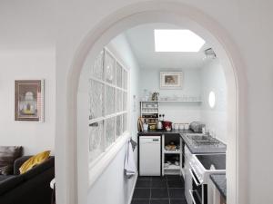 a kitchen with an archway leading into a kitchen with a stove at Seagulls Nest in Hastings