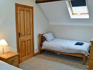 a small bedroom with a bed and a window at Aden Barn in Allonby