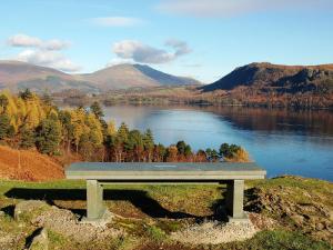 a bench sitting on top of a hill overlooking a lake at Aden Barn in Allonby