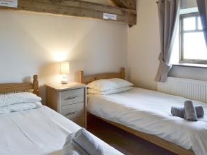 フランボローにあるBlackbird Cottage - 25116のベッドルーム1室(ベッド2台、ランプ、窓付)
