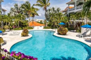 a swimming pool at a resort with palm trees at Shore to Please - Large Studio Condo in Turtle Cove