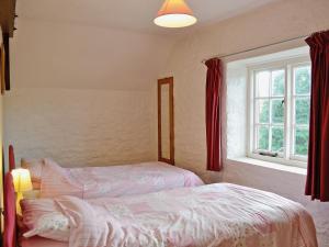 a bedroom with a bed and a window at Cider Cottage - E5576 in Warkleigh