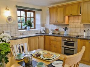 a kitchen with a table with a plate of food on it at Cider Cottage - E5576 in Warkleigh