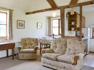salon z kanapą, krzesłami i stołem w obiekcie Stable Cottage w mieście Ticehurst