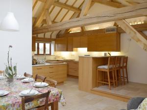 a kitchen with a table and a kitchen with wooden cabinets at Low Farm Barn in Laxfield