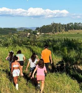 un grupo de personas caminando por un campo en Casa de Campo Província Minosso, en Farroupilha