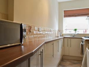 a kitchen with a counter top with a microwave at Cottage On The Green in York