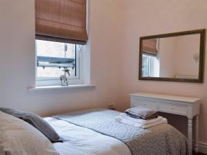 a bedroom with a bed and a mirror at Cottage On The Green in York