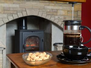 a cup of coffee and a bowl of food on a table with a fireplace at Ashlea in Barnard Castle