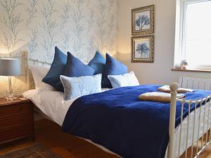 Burton in LonsdaleにあるBluebell Cottageのベッドルーム1室(青と白の枕が備わるベッド1台付)