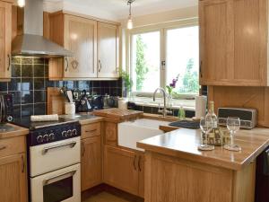 a kitchen with wooden cabinets and a stove top oven at Larkspur in Hollington