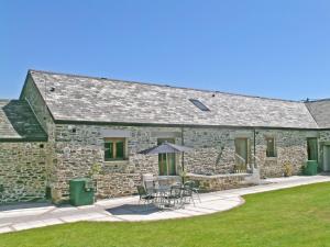 a stone house with tables and chairs in front of it at What A Beauty - Thr in Tresmeer