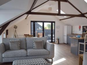 a living room with a couch and a kitchen at Derbys Loft in Beccles